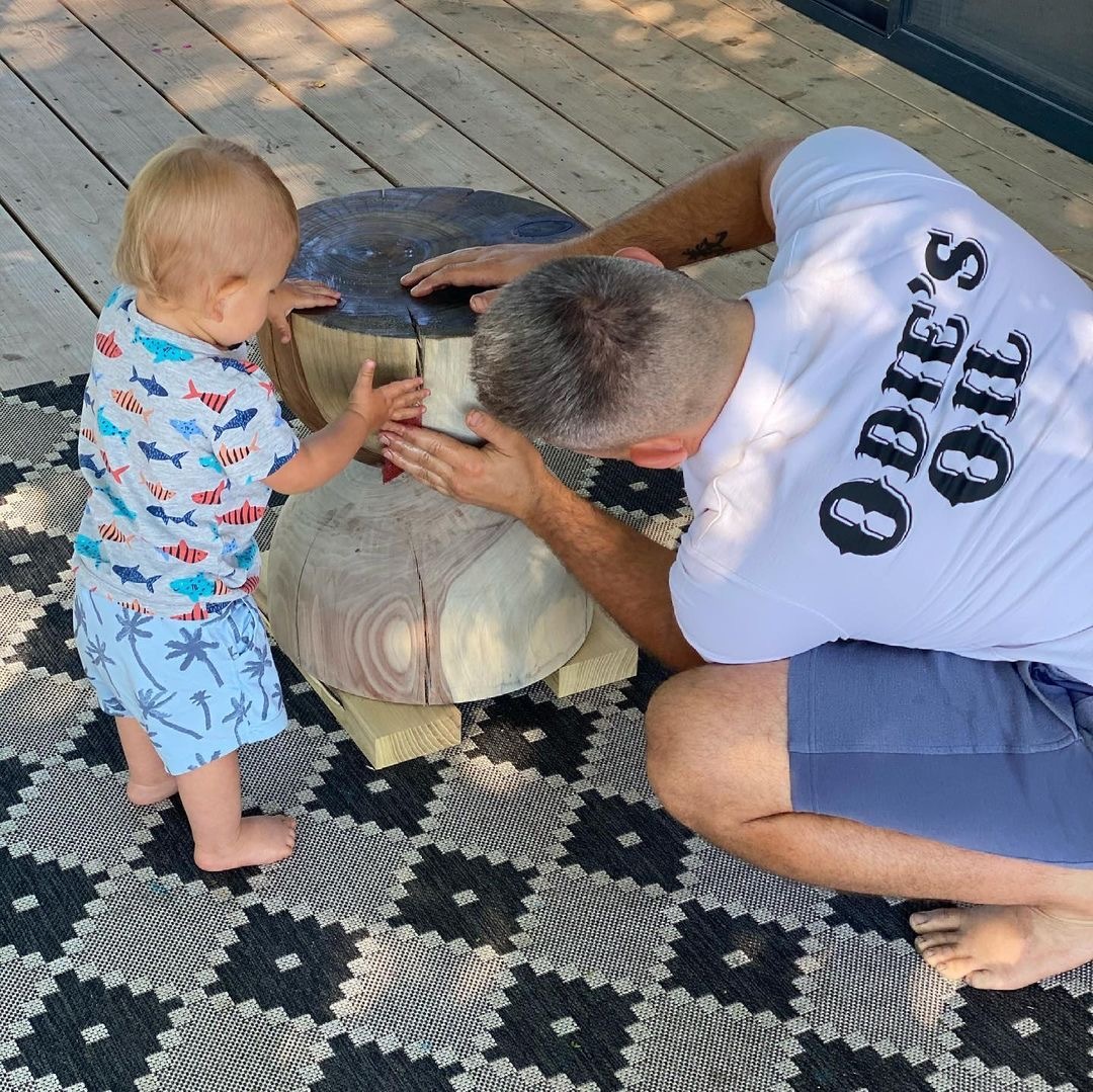 man and baby finishing a wood table